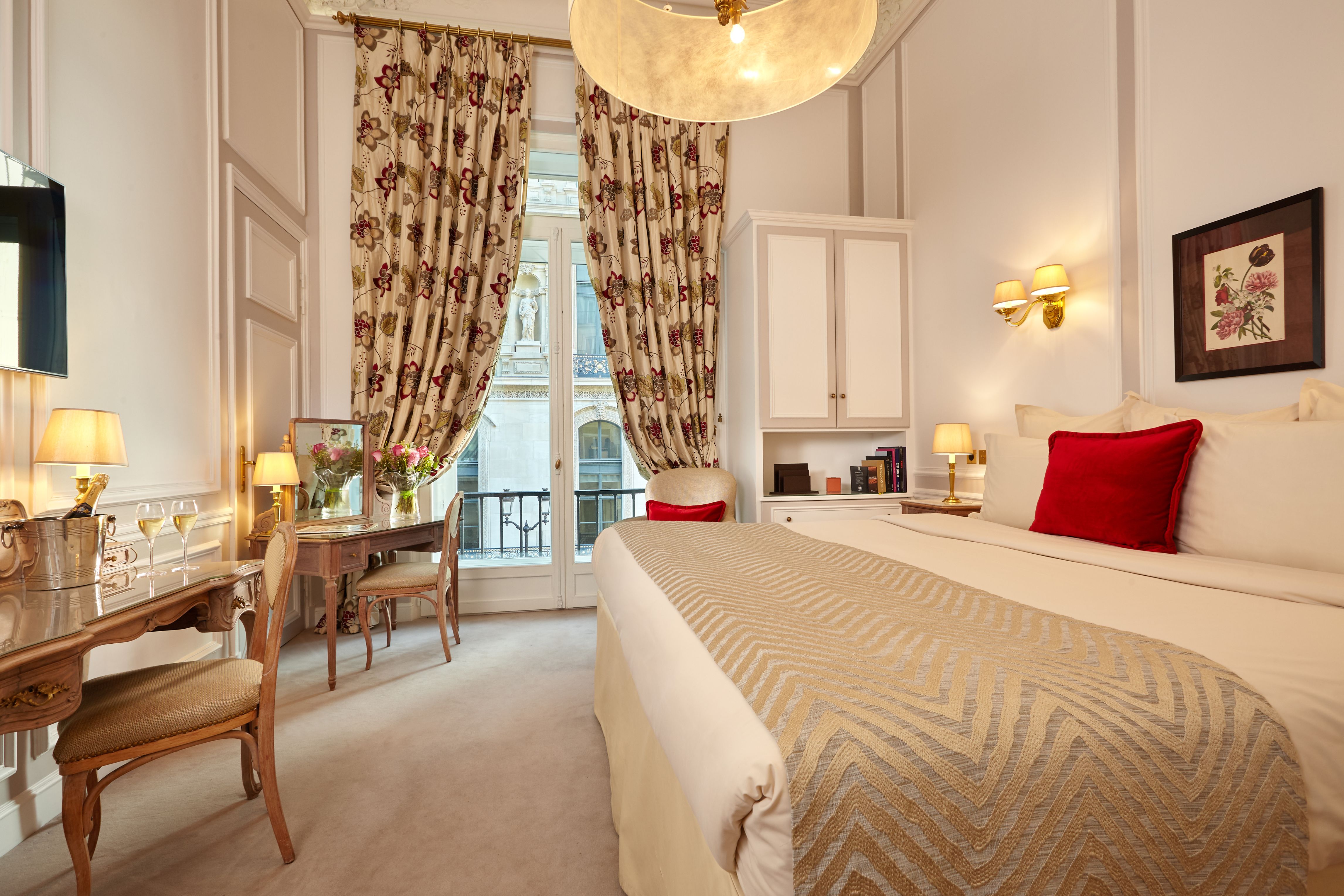 a bedroom with a bed and a desk and chairs