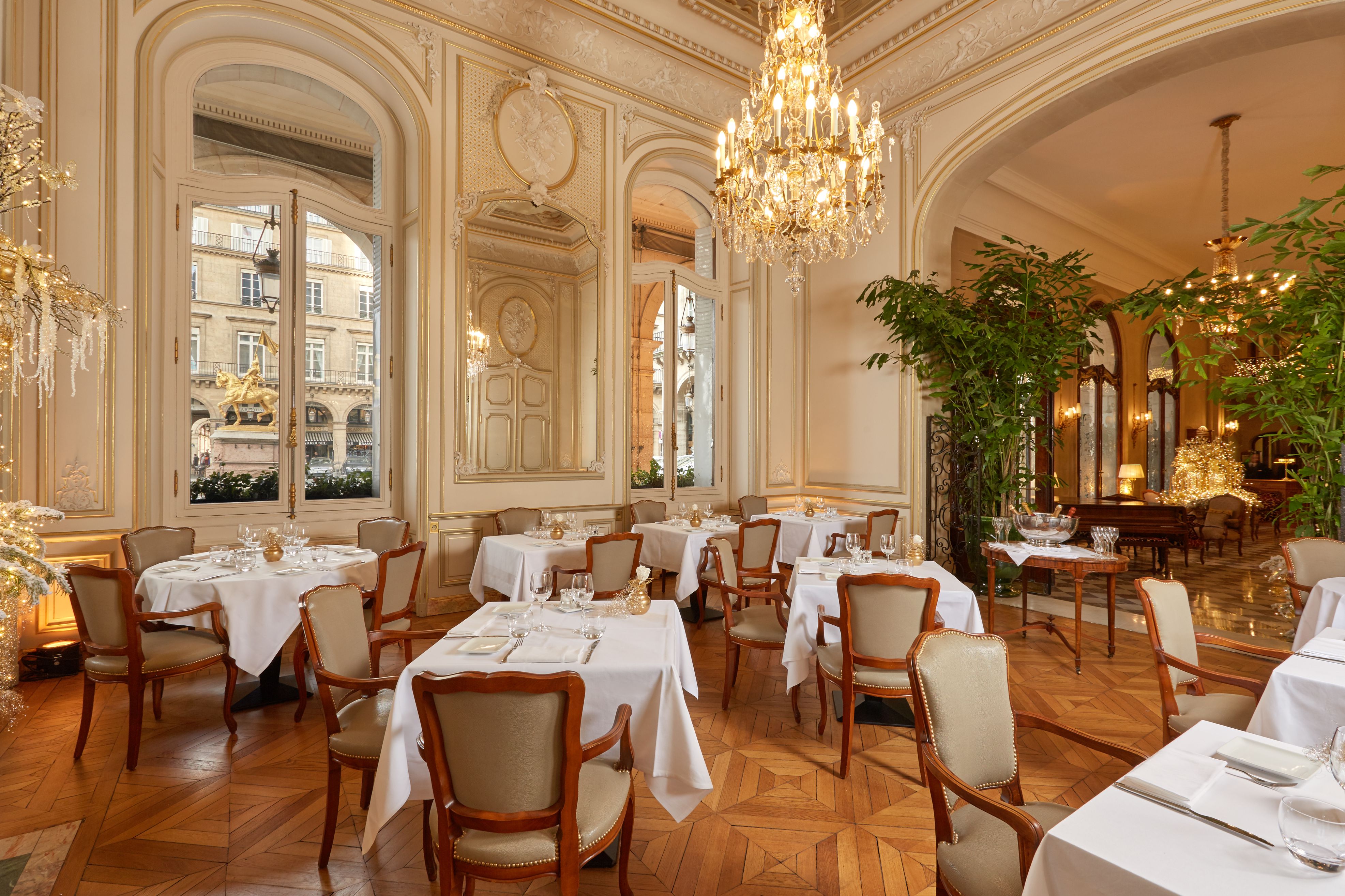 a room with tables and chairs and chandeliers