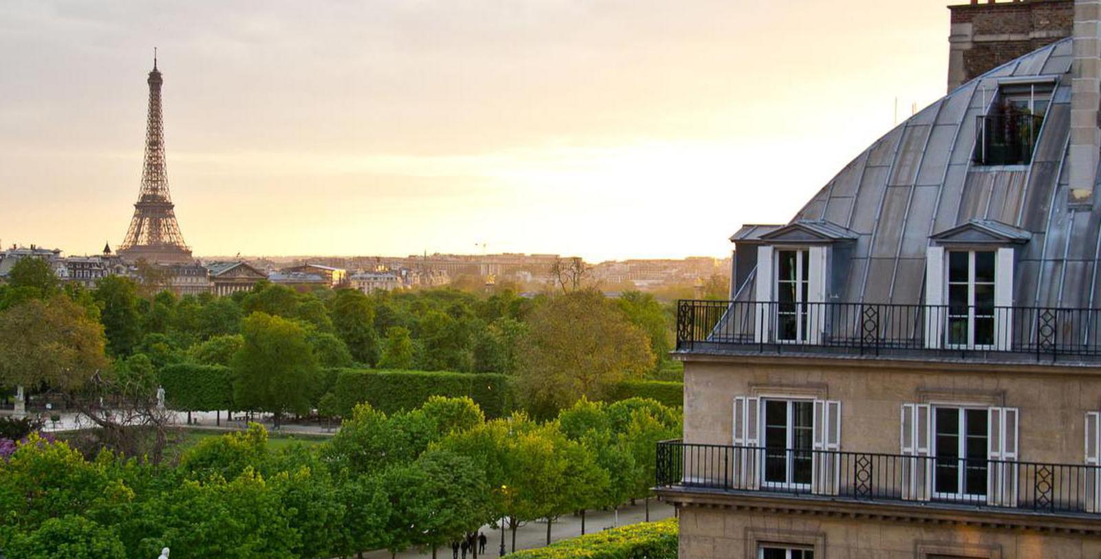 a building with a balcony and trees in the background