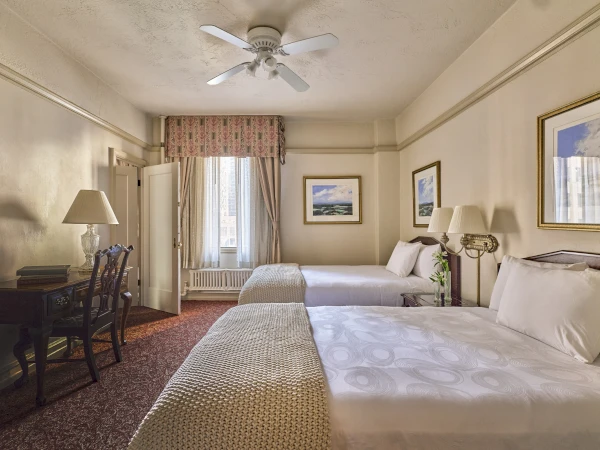 a room with two beds and a ceiling fan