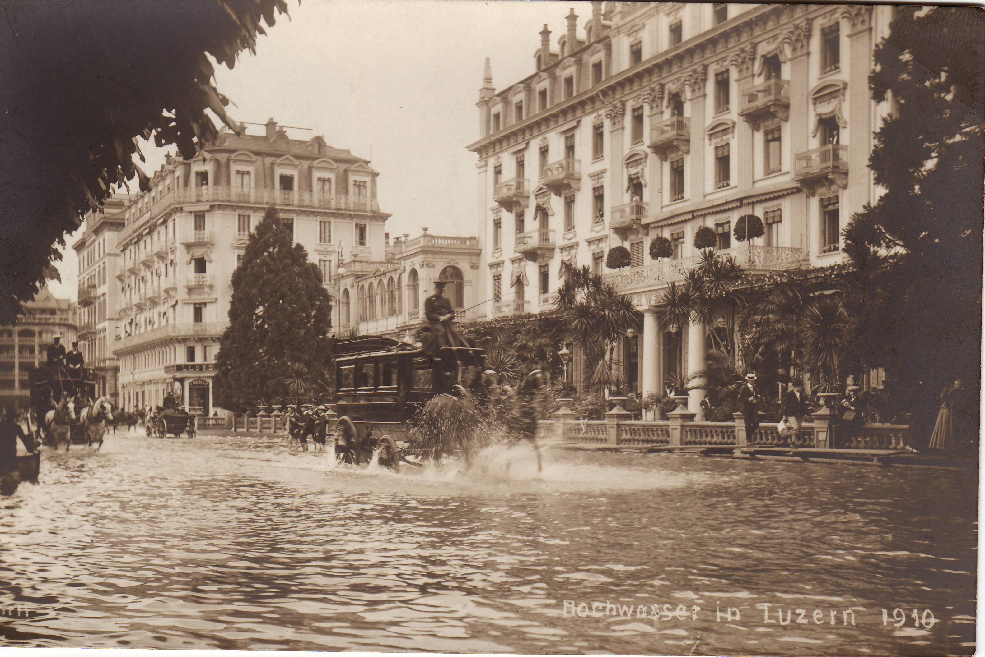a horse drawn carriage in water with people in front of buildings