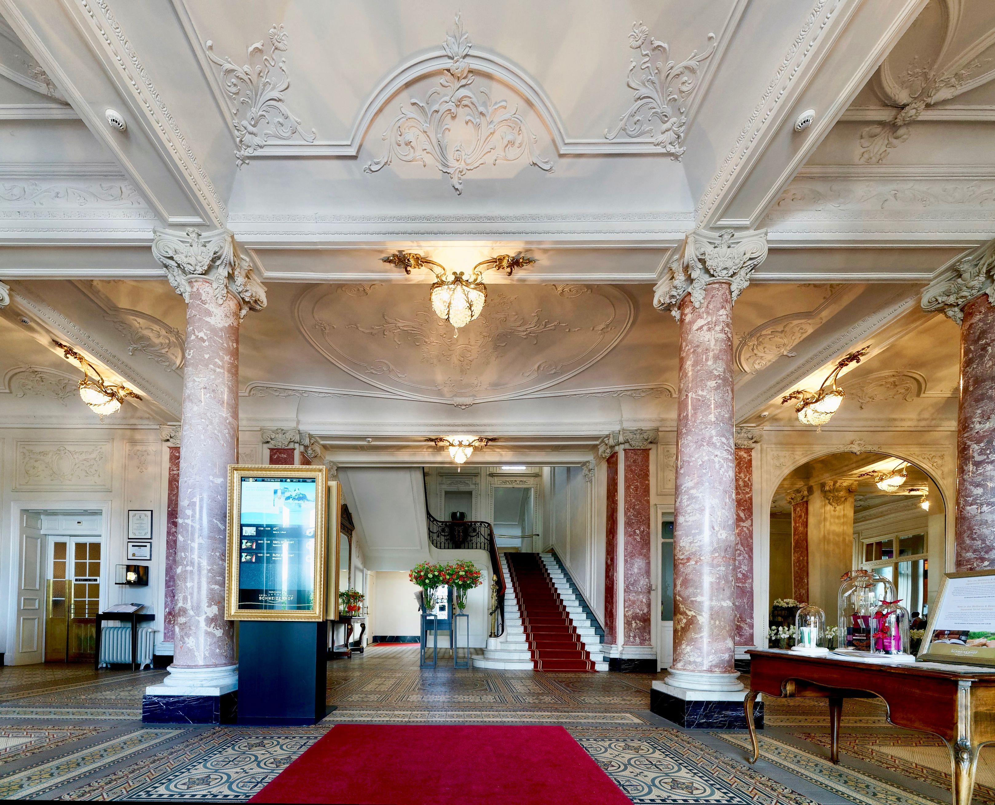 a large white building with columns and red carpet