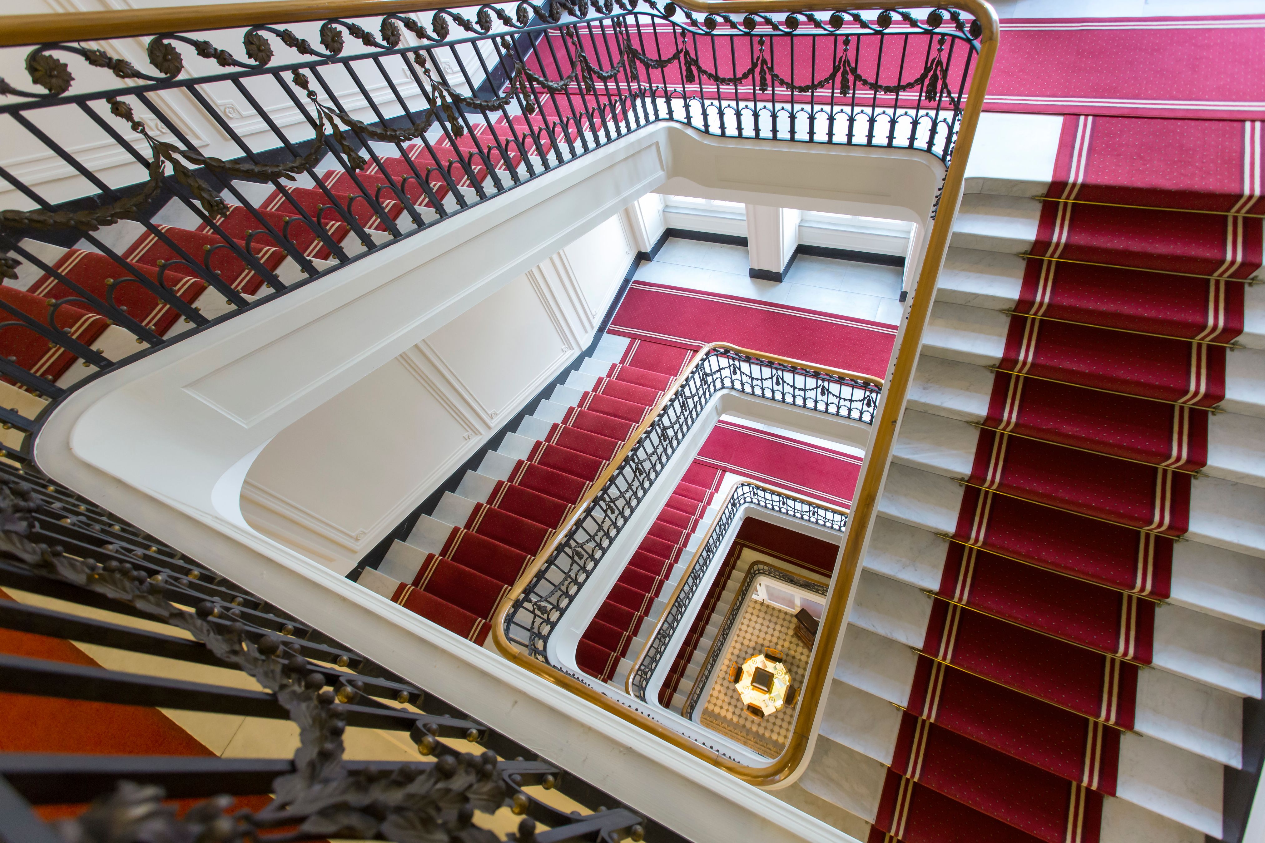 a staircase with red carpet and black railings