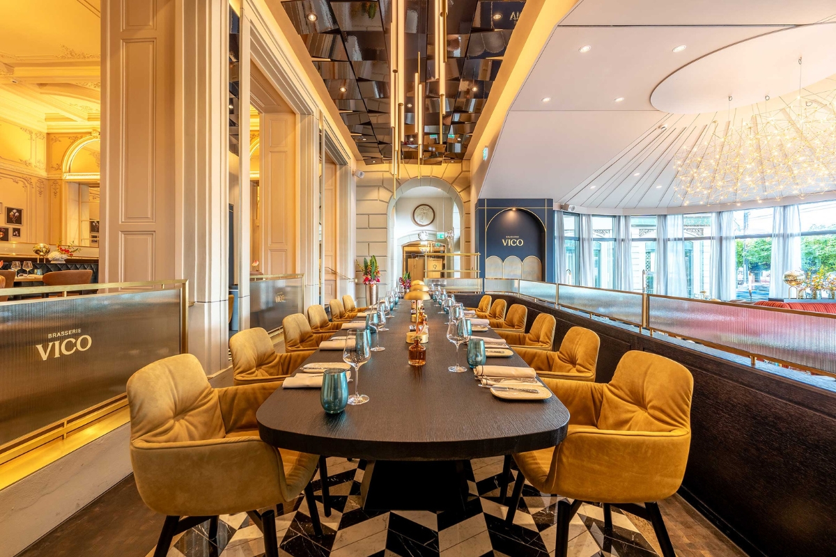a long table with chairs and a glass of wine