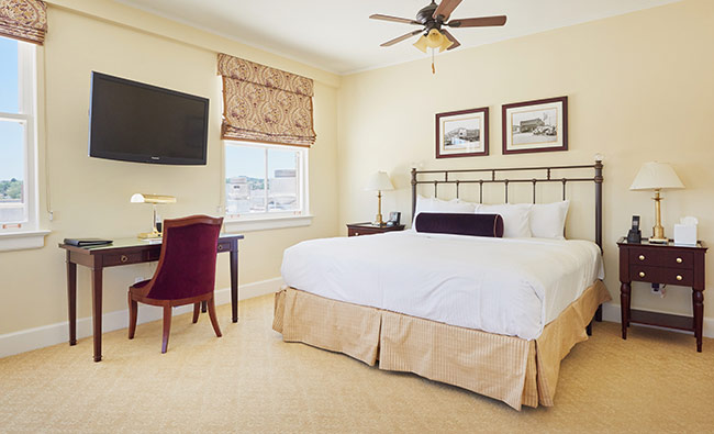 a bedroom with a desk and a tv