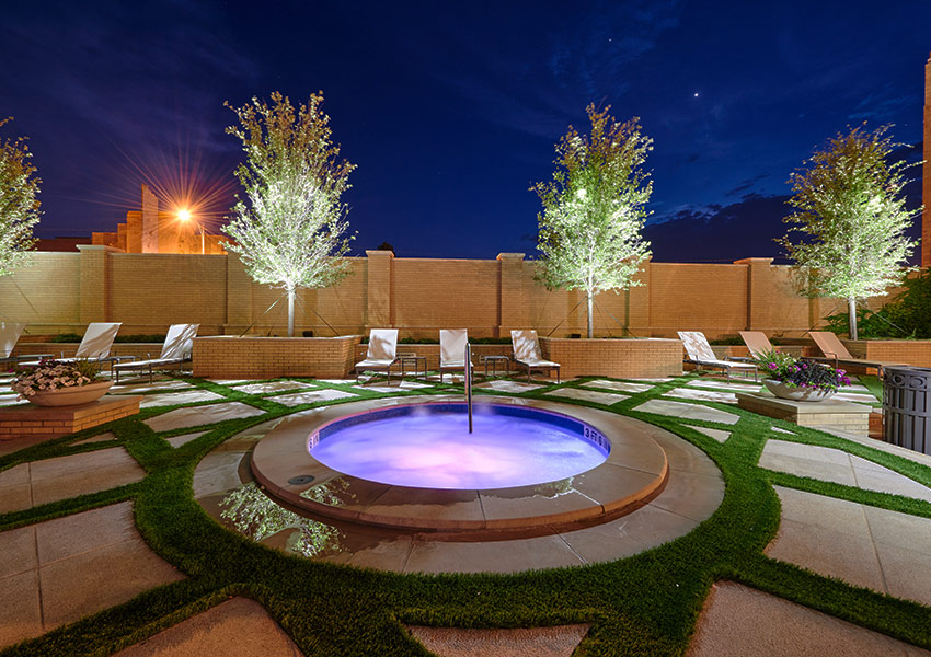 a pool with a hot tub and chairs around it