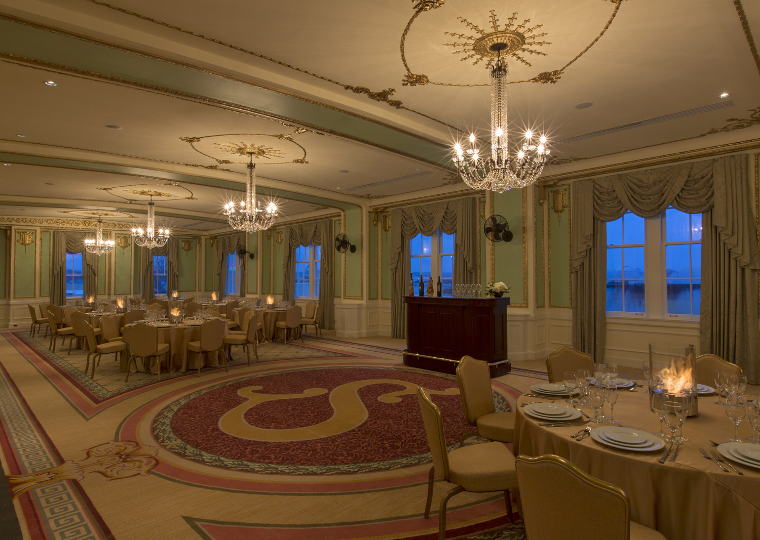 a room with tables and chairs and chandeliers
