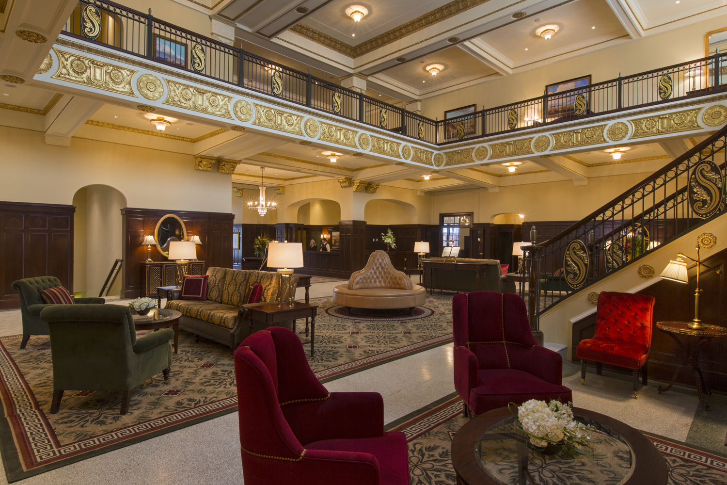 a room with a large sofa and chairs