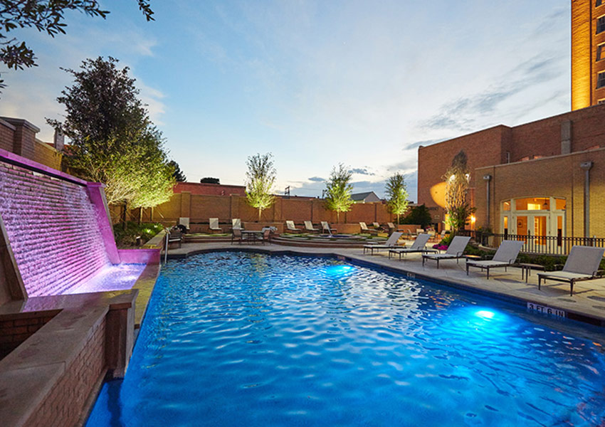 a pool with a fountain and chairs