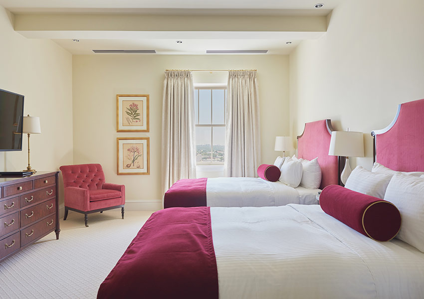 a room with two beds and a chair