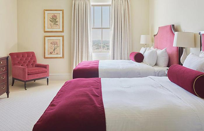 a bedroom with two beds and a red chair