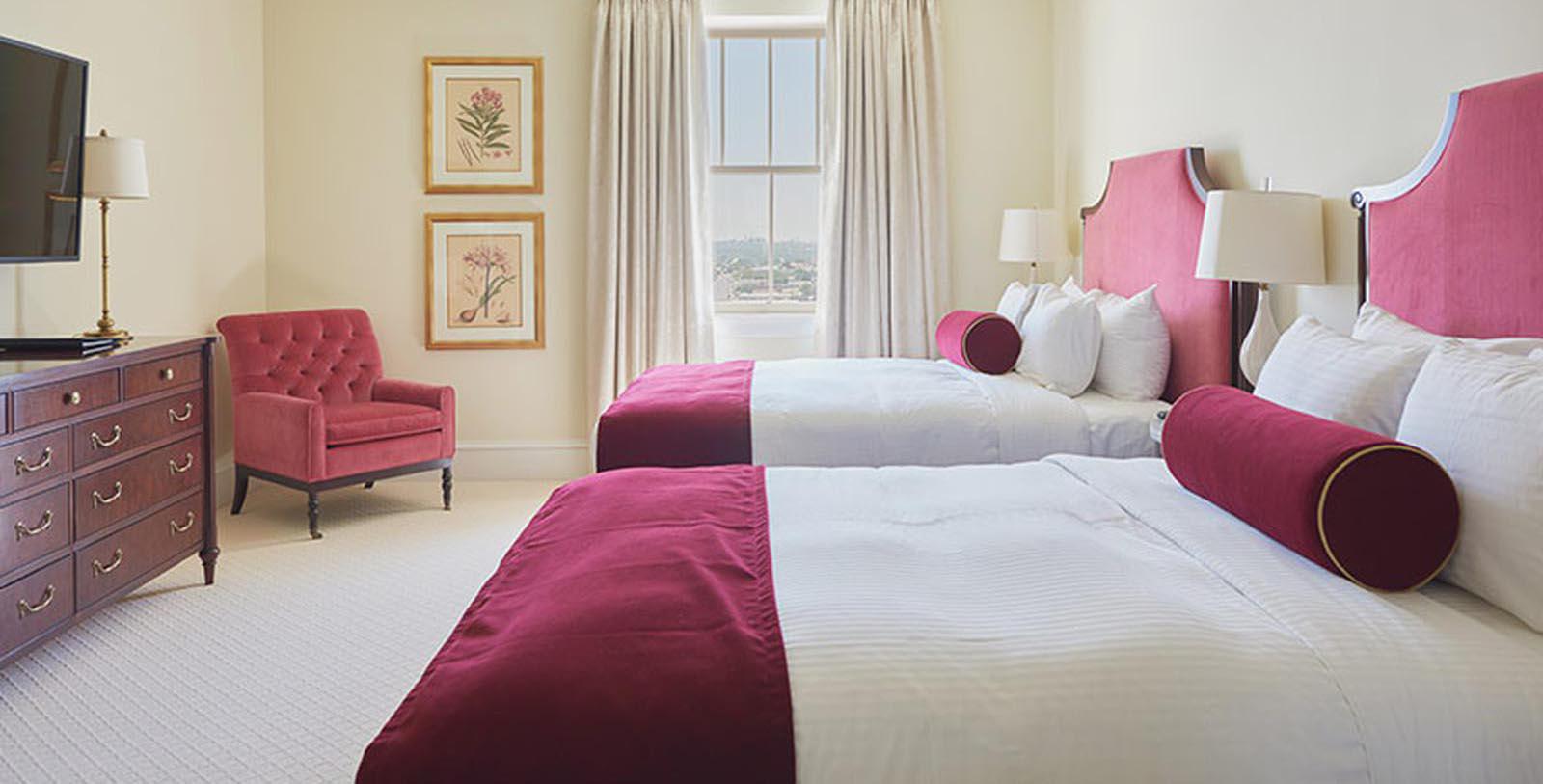 a bedroom with two beds and a red chair