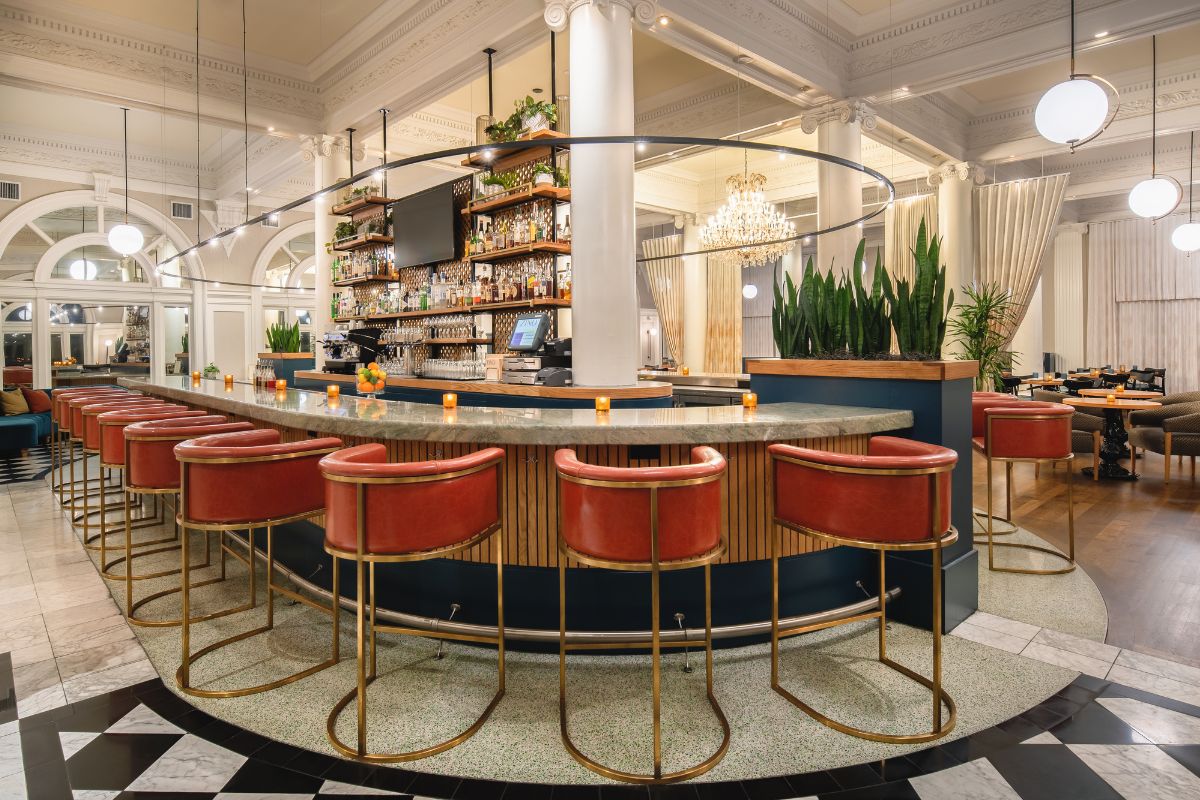 a bar with red chairs and a black and white checkered floor