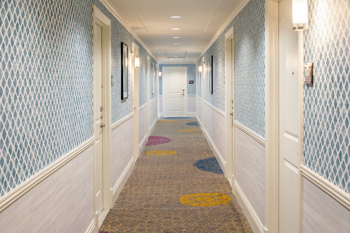 a long hallway with doors and a patterned carpet