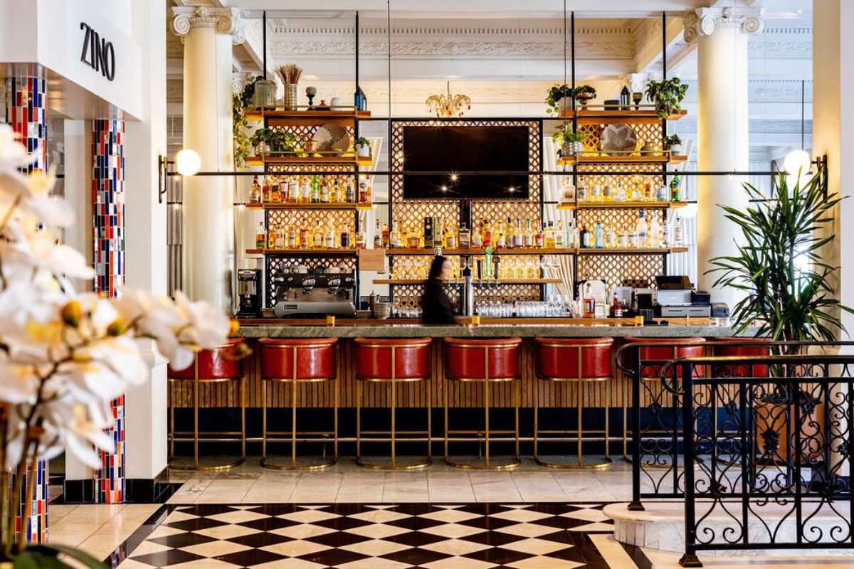 a bar with a counter and shelves of bottles