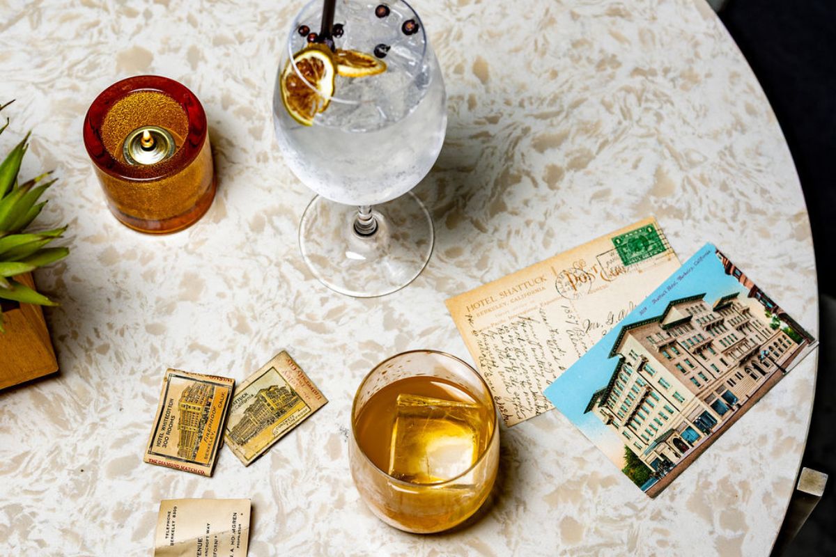 a glass of liquid and postcards on a table