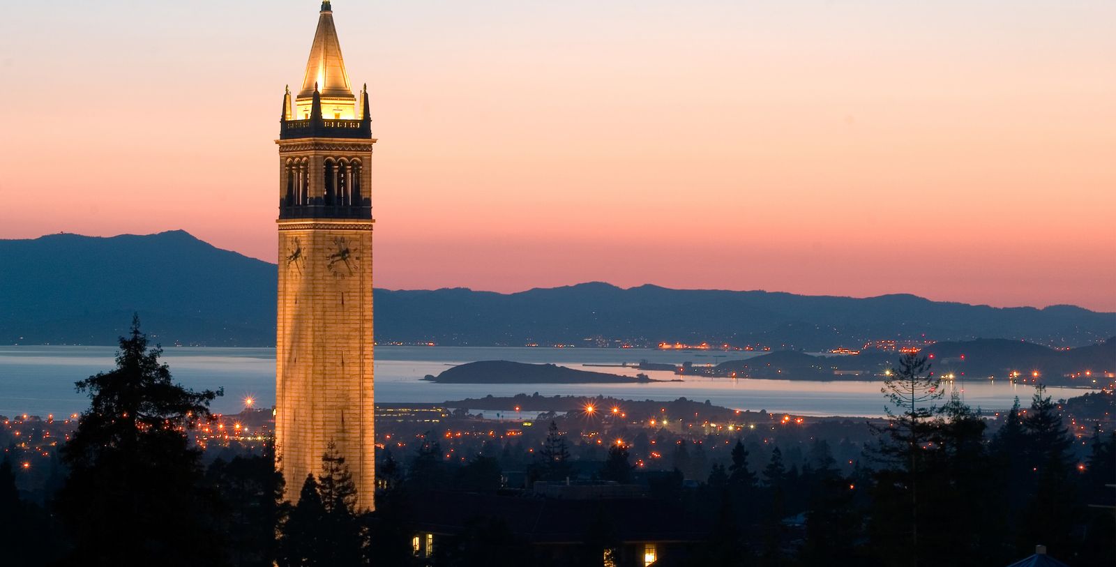 a tall tower with a pointy top and a city in the background