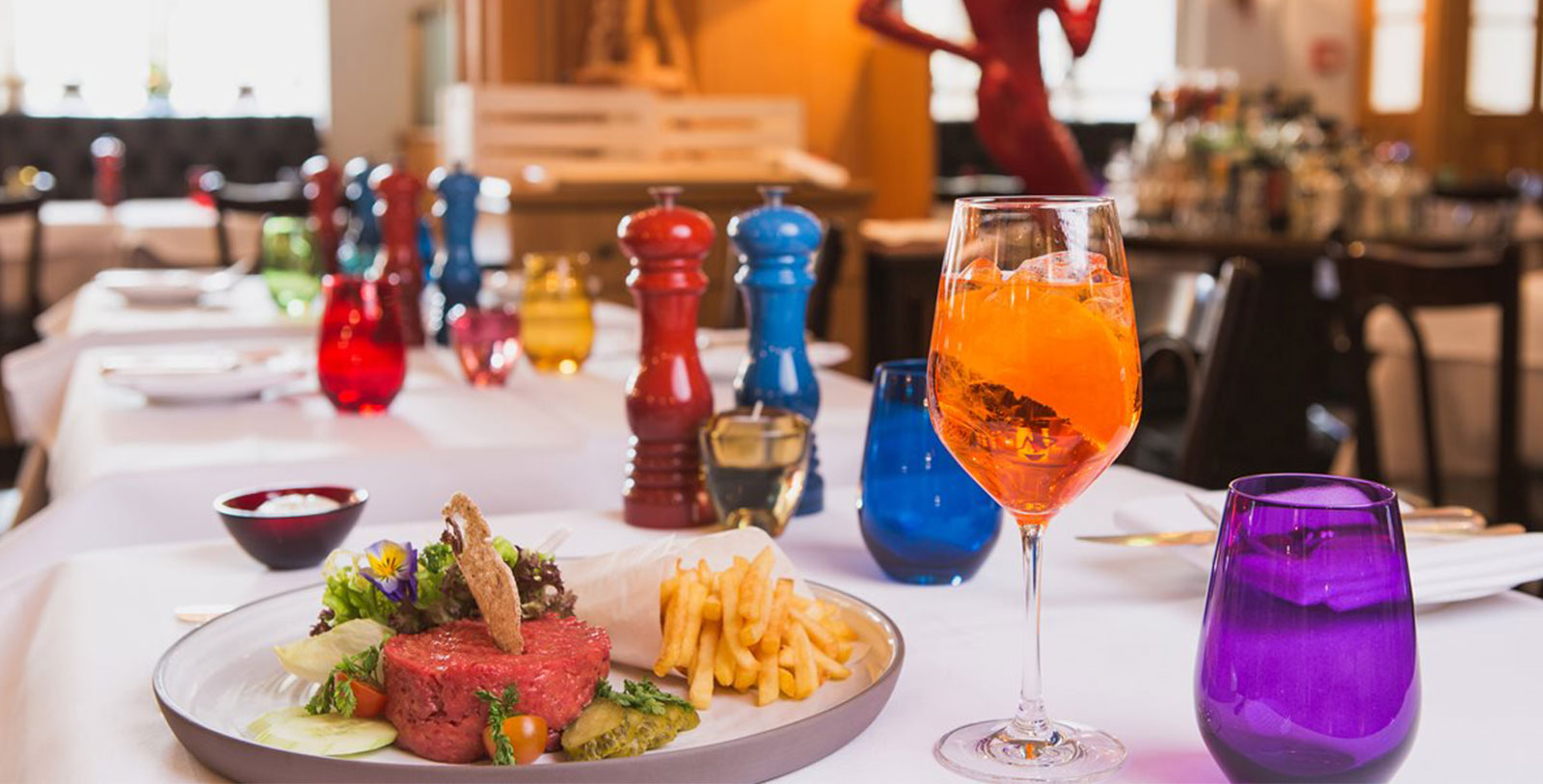 a plate of food and a glass of orange liquid on a table