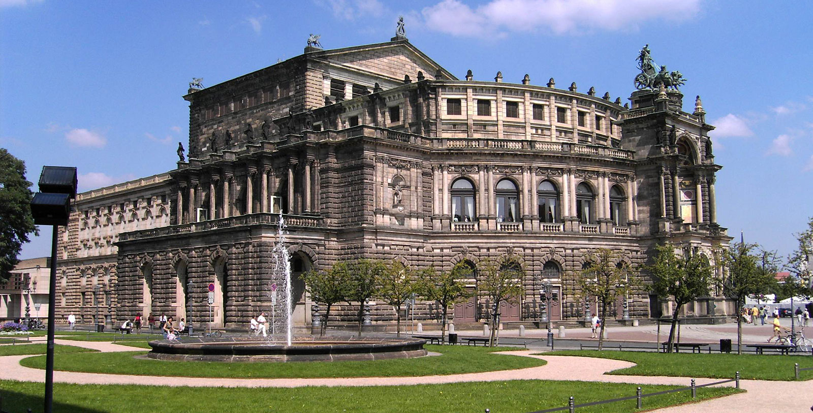 a large building with a fountain in front with Semperoper in the background