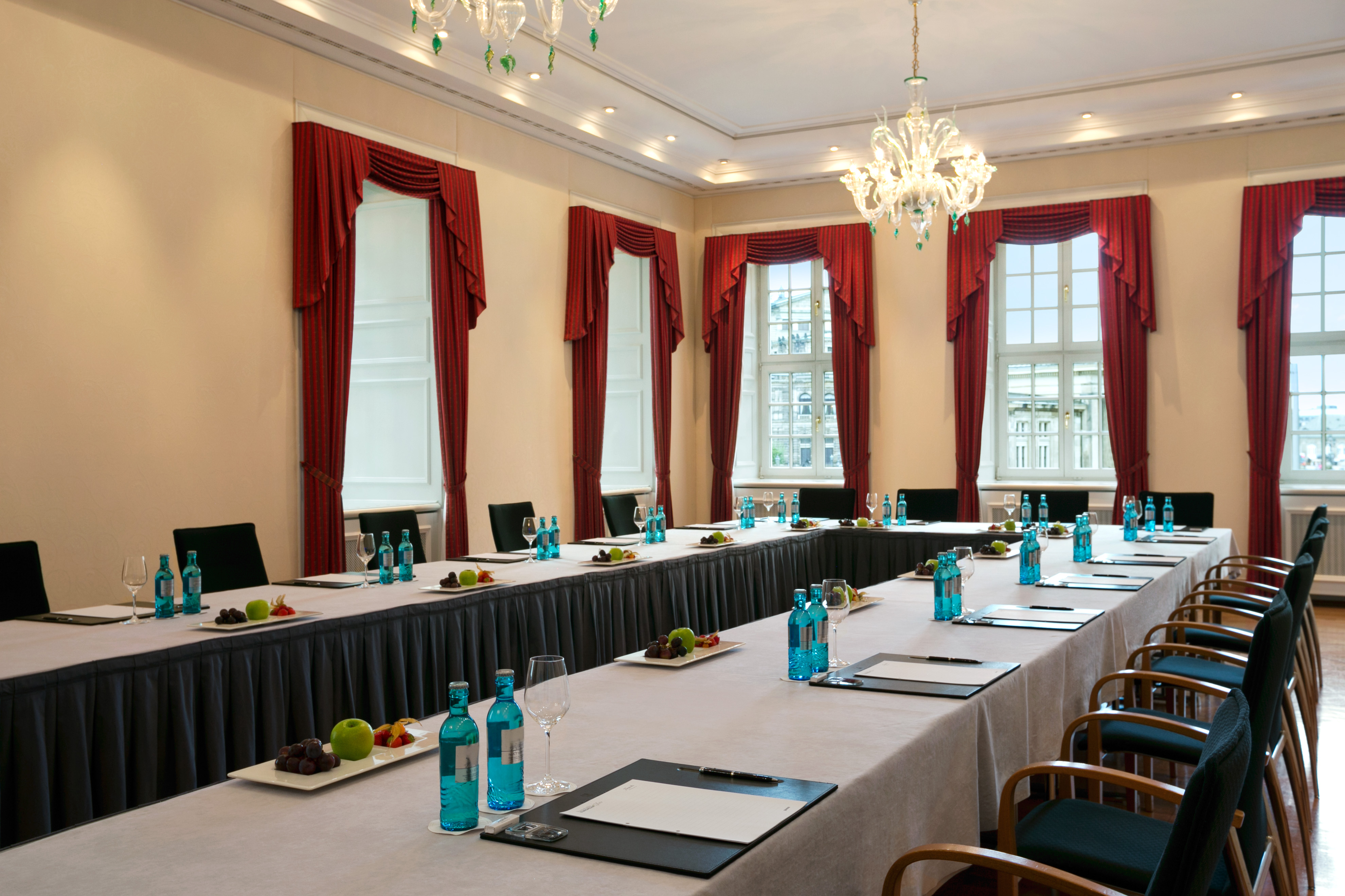a long table with plates of water and glasses on it