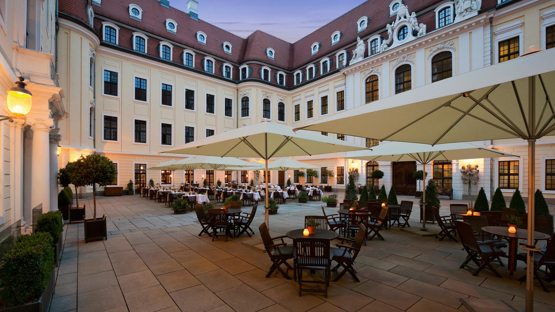 a courtyard with tables and umbrellas
