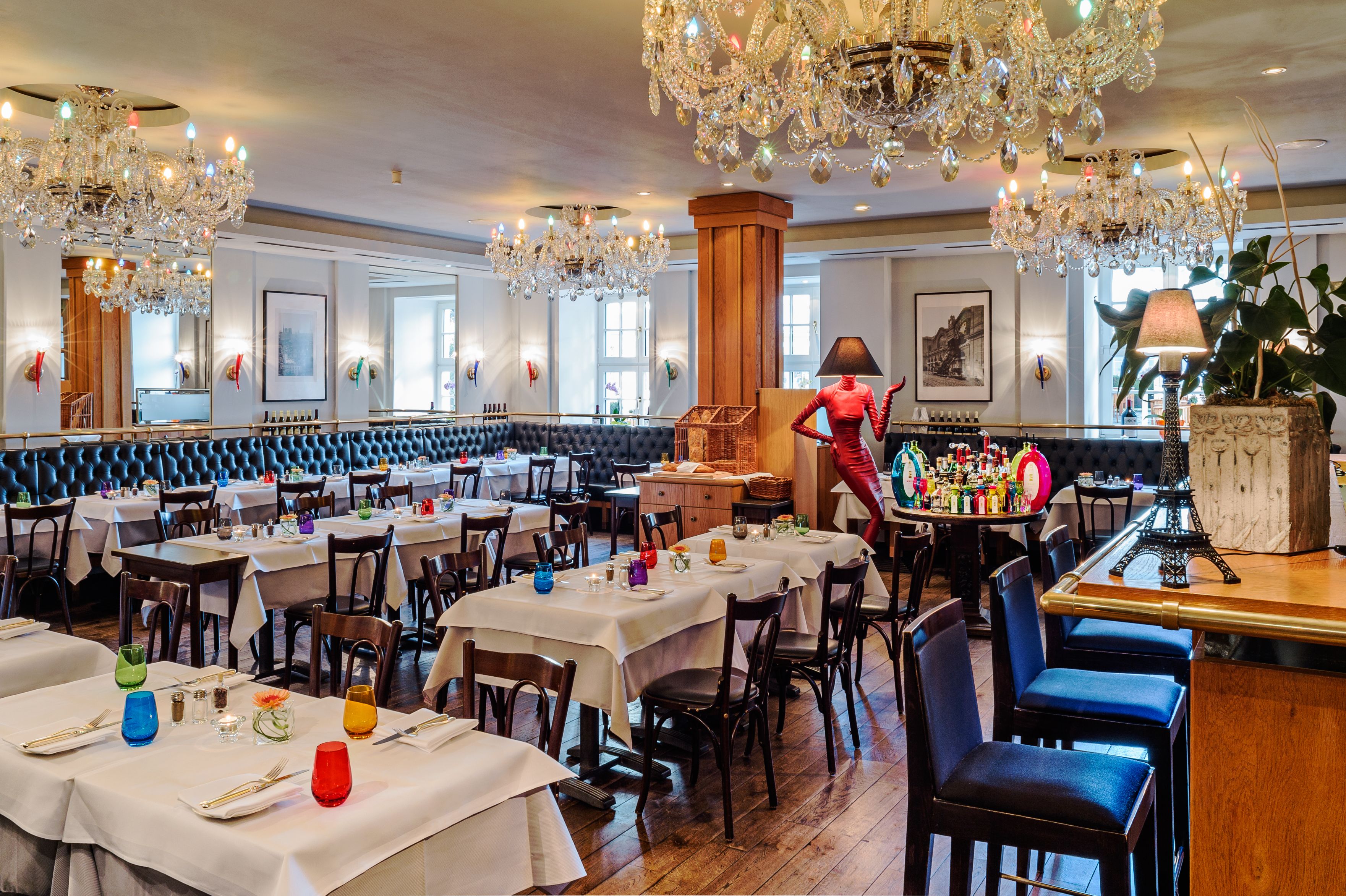 a room with tables and chairs and chandeliers