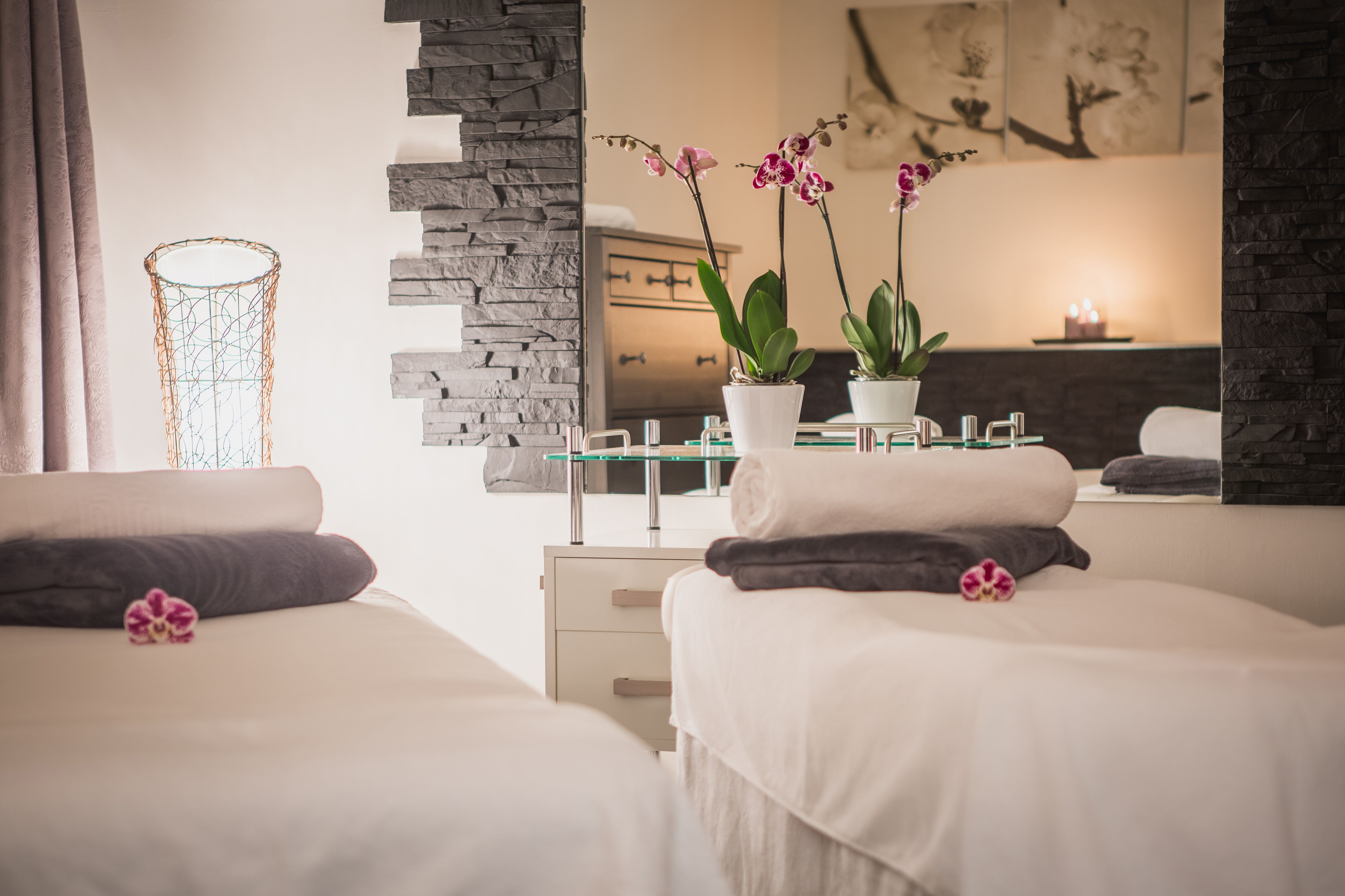a massage room with towels and flowers