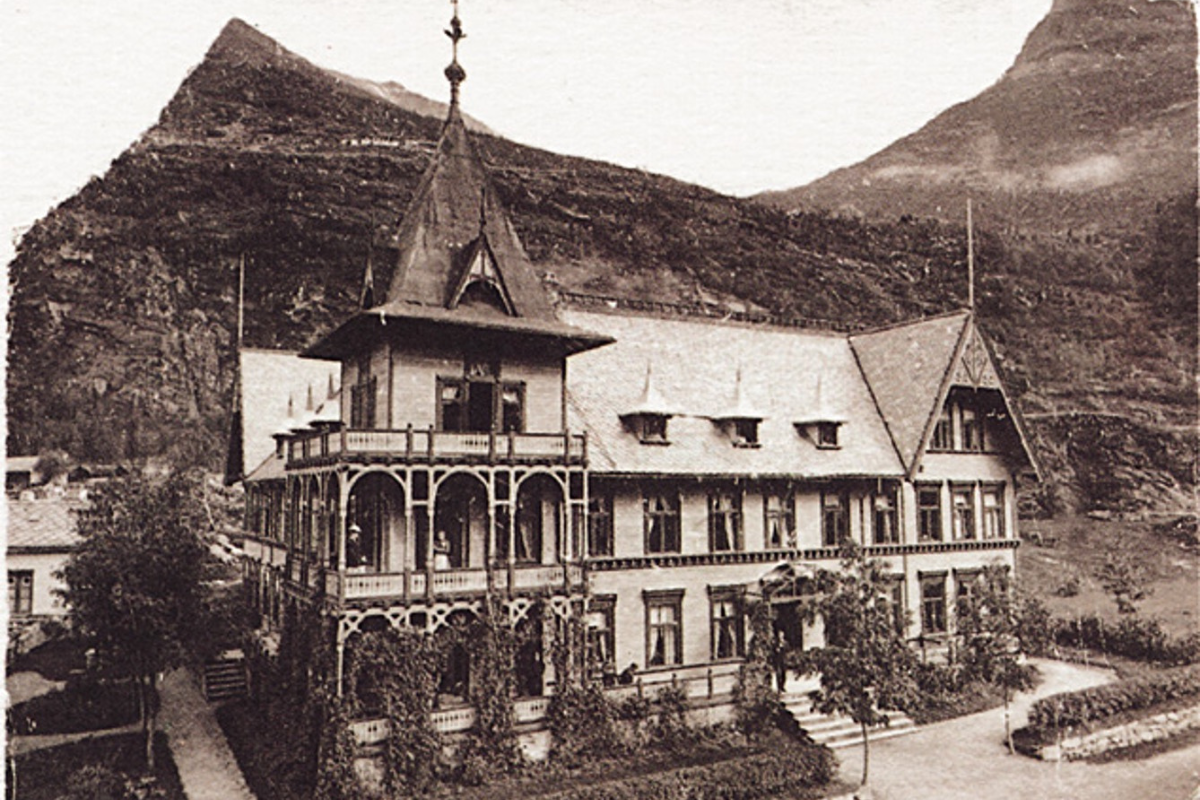 a large building with a steeple and a mountain in the background