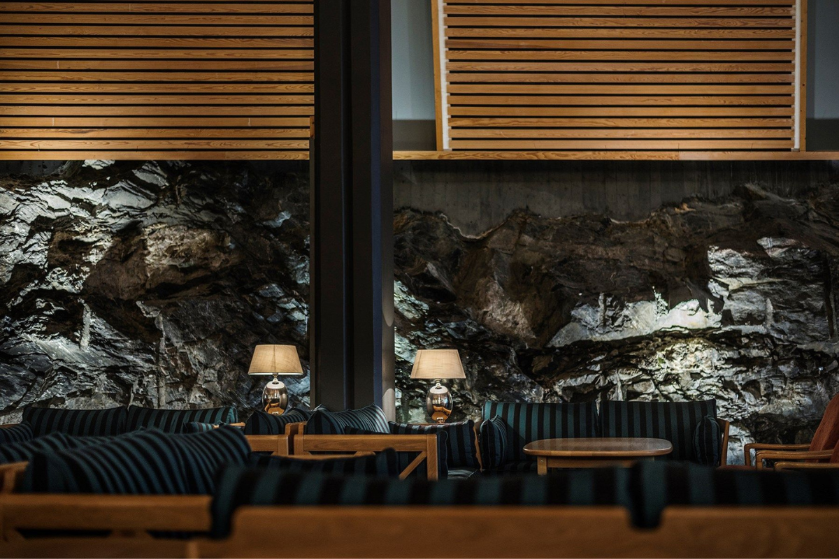 a room with a rock wall and a table with lamps