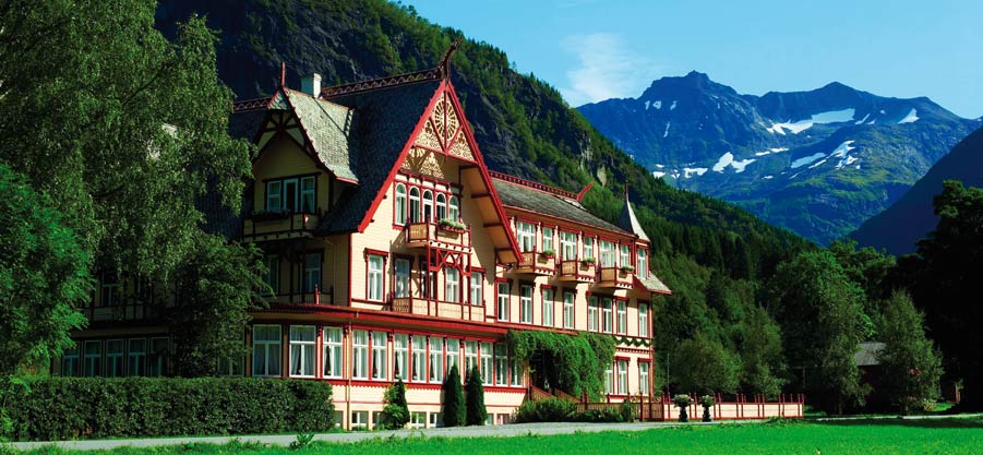 a large building with mountains in the background