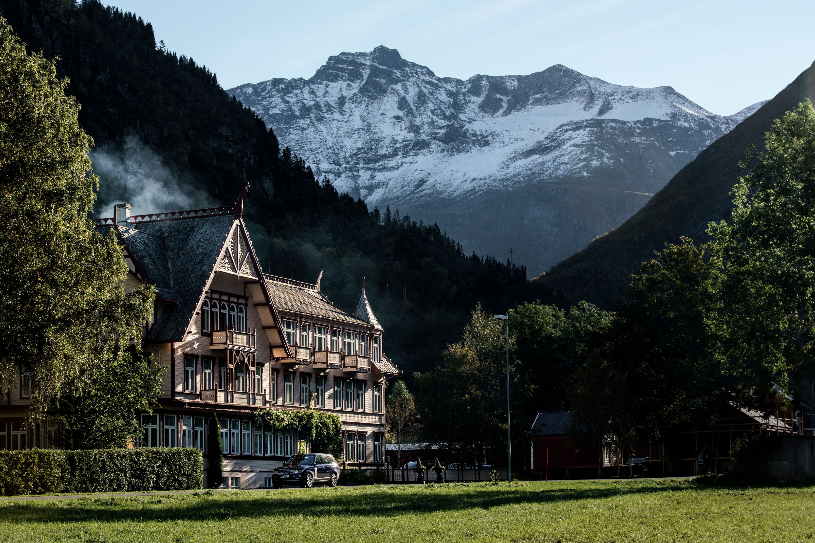 a building with trees and mountains in the background