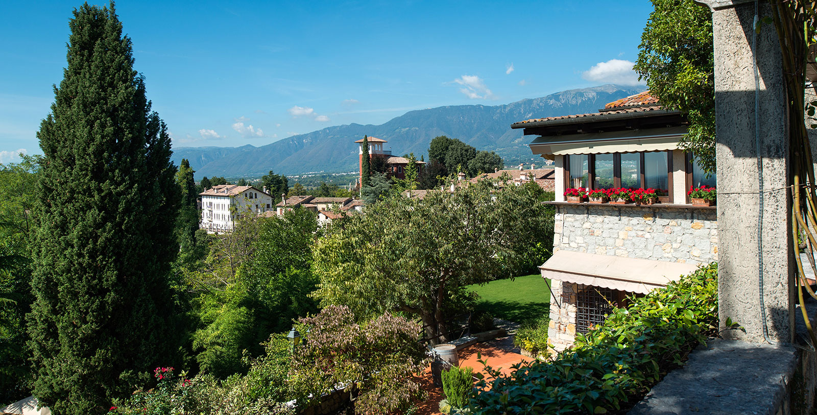a building with trees and mountains in the background