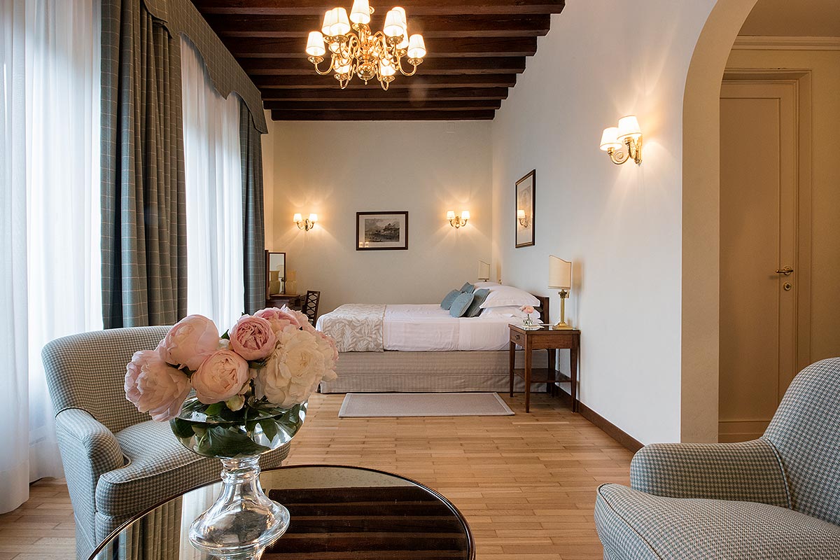 a room with a bed and a vase of flowers