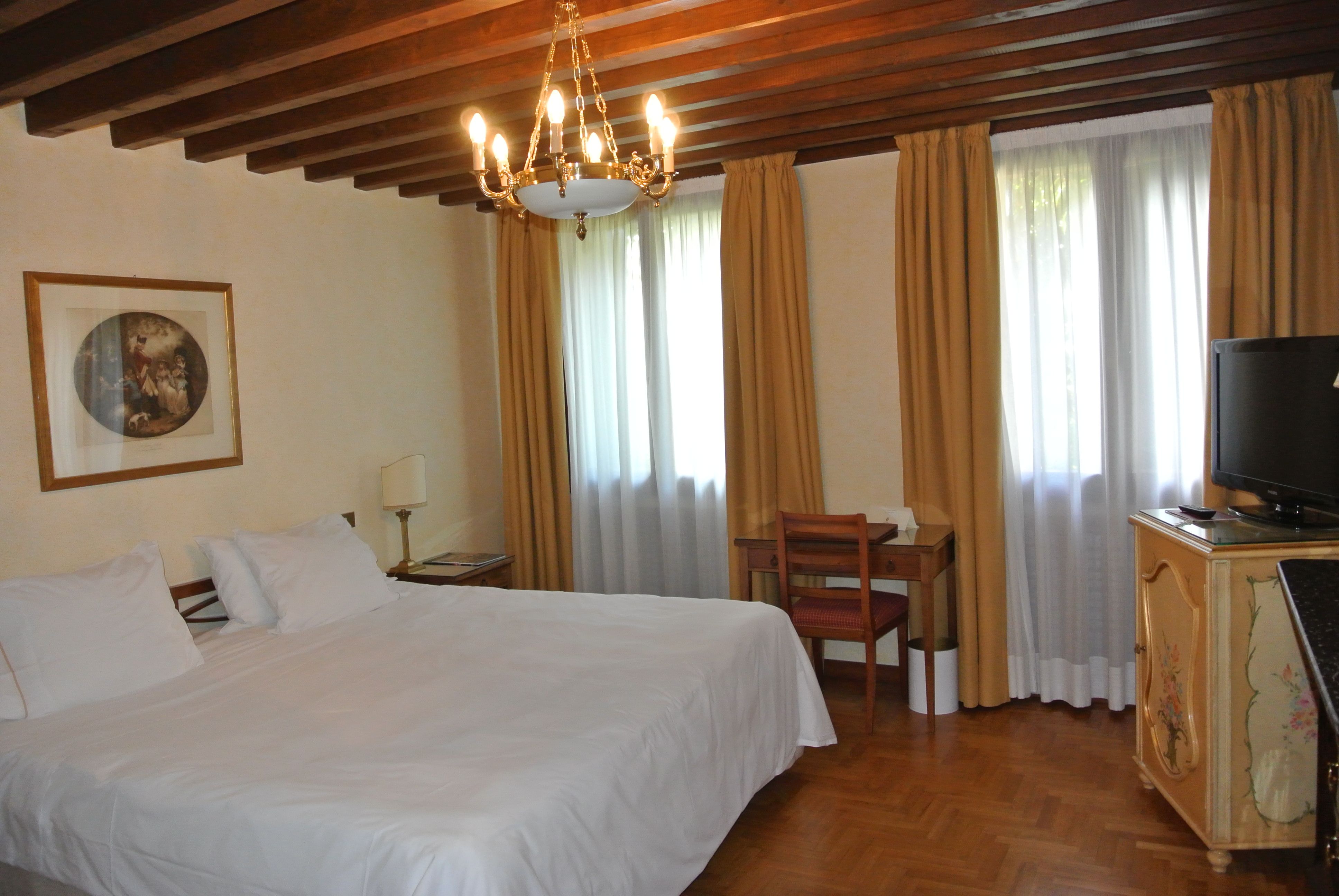 a bedroom with a bed and a chandelier