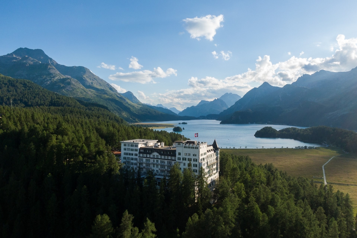 a building surrounded by trees and mountains