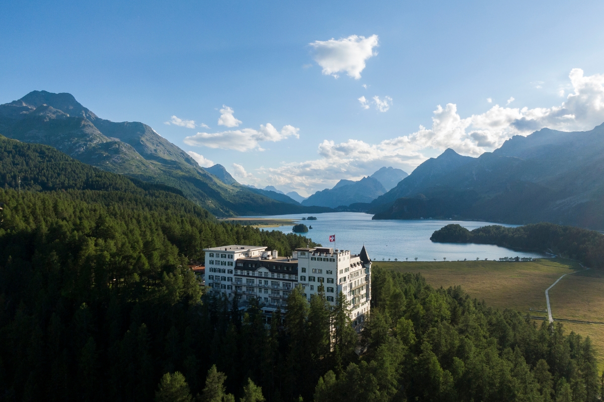 a building surrounded by trees and mountains