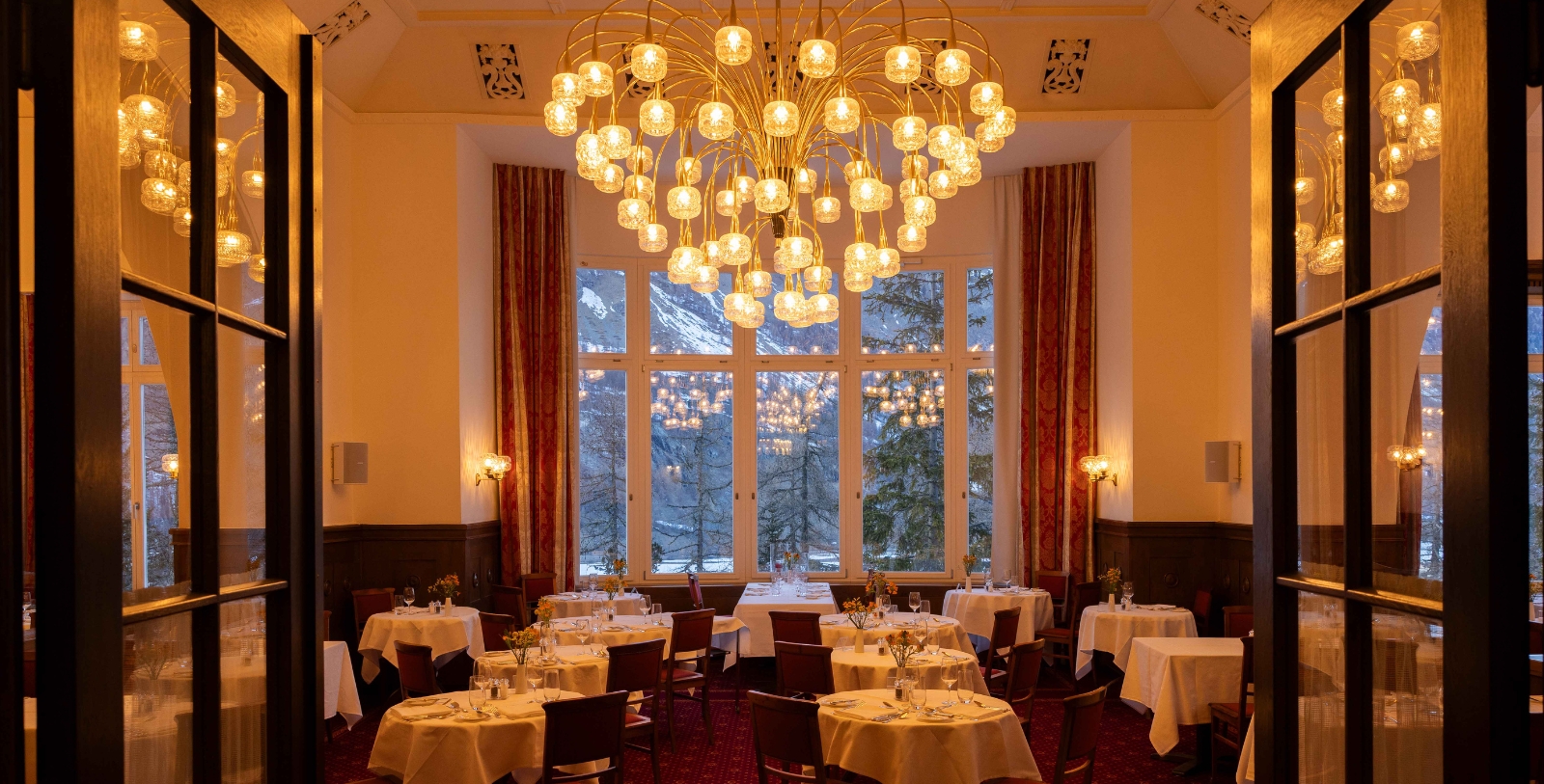a room with tables and chairs and a chandelier