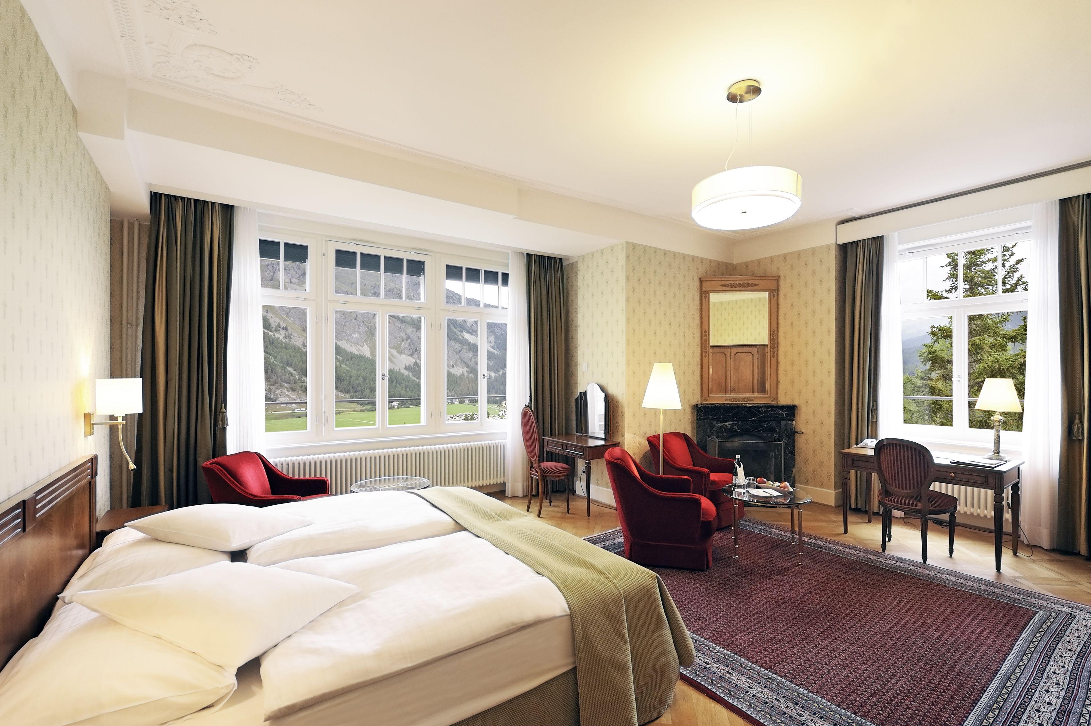a room with a bed and chairs