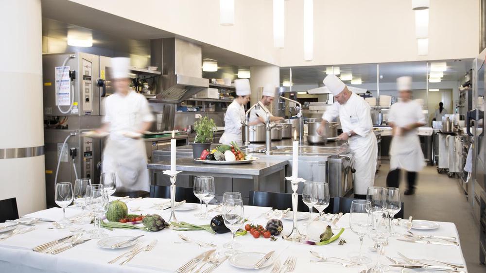 a group of chefs preparing food in a kitchen