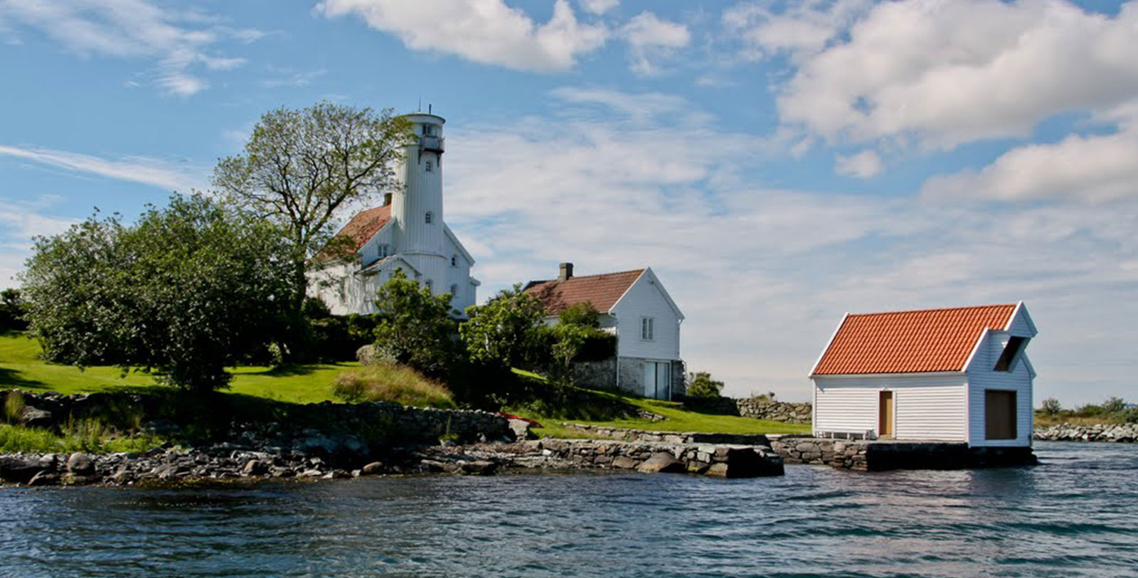 a white house next to a body of water