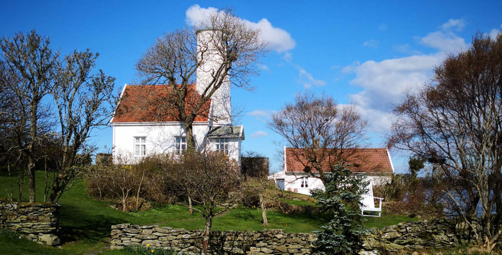a white house with a tower and trees