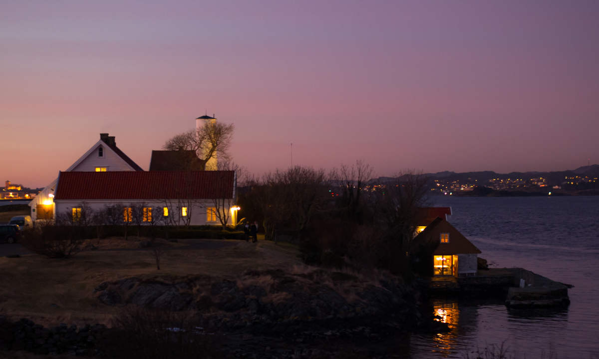 a group of houses on a hill next to water