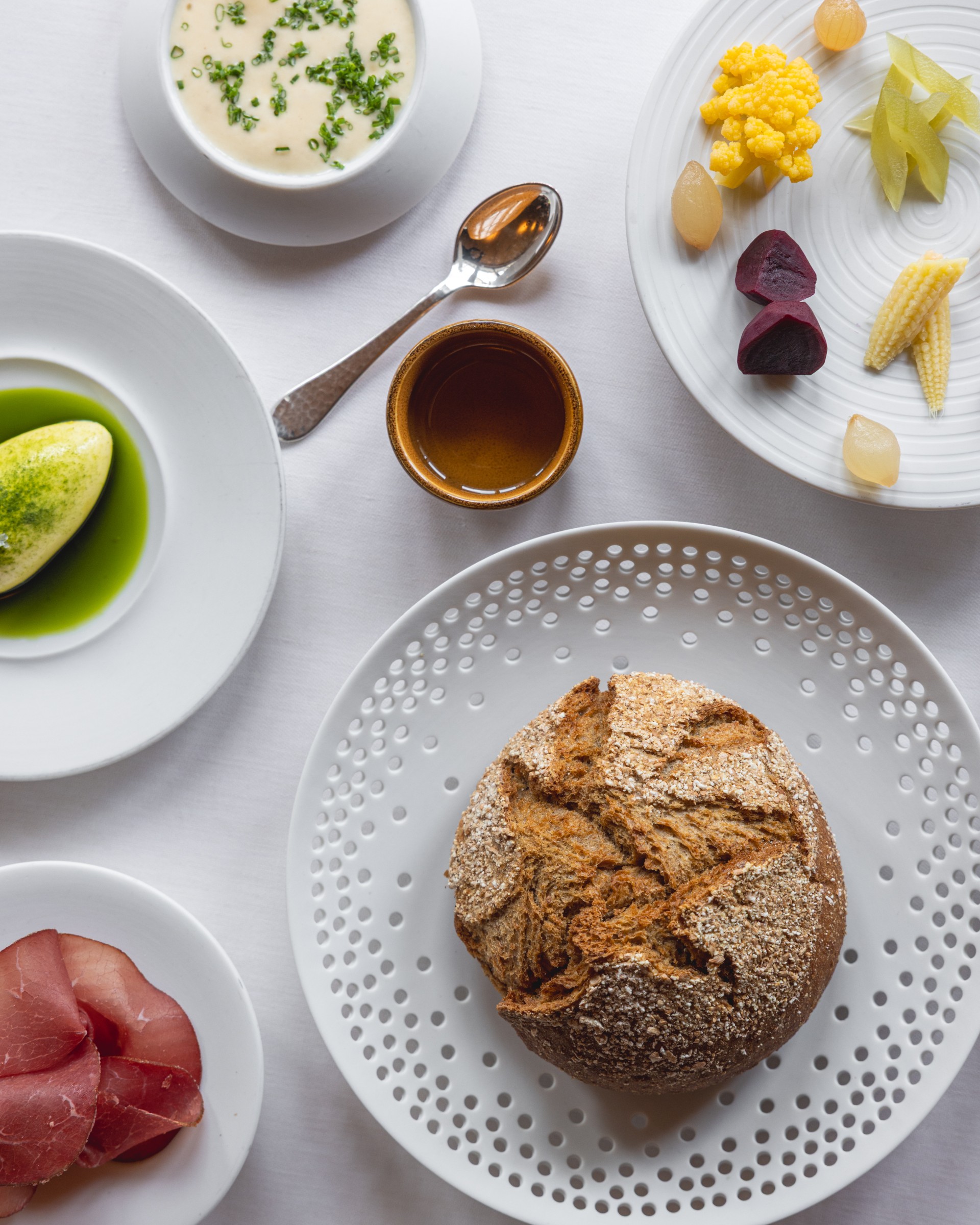 a table with plates of food and a spoon
