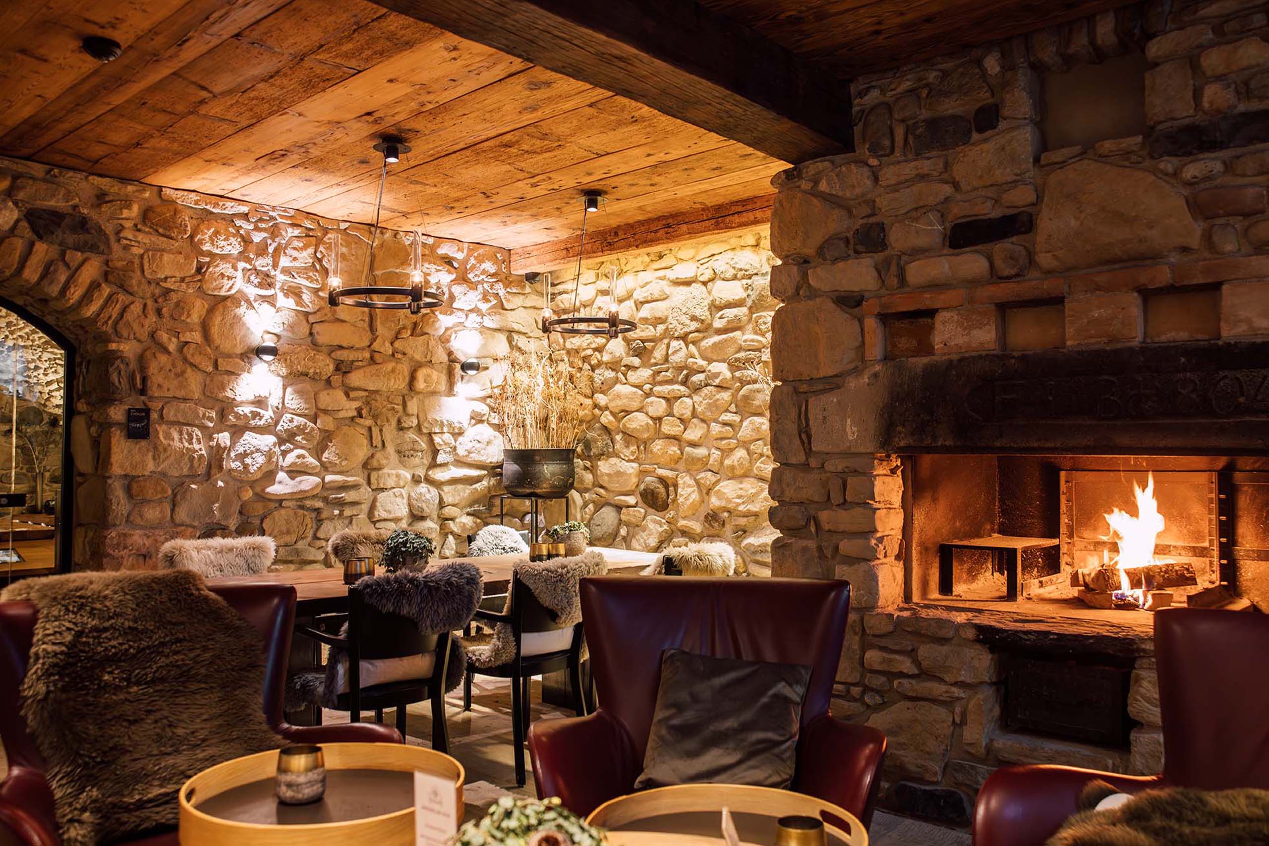 a room with a stone fireplace and tables