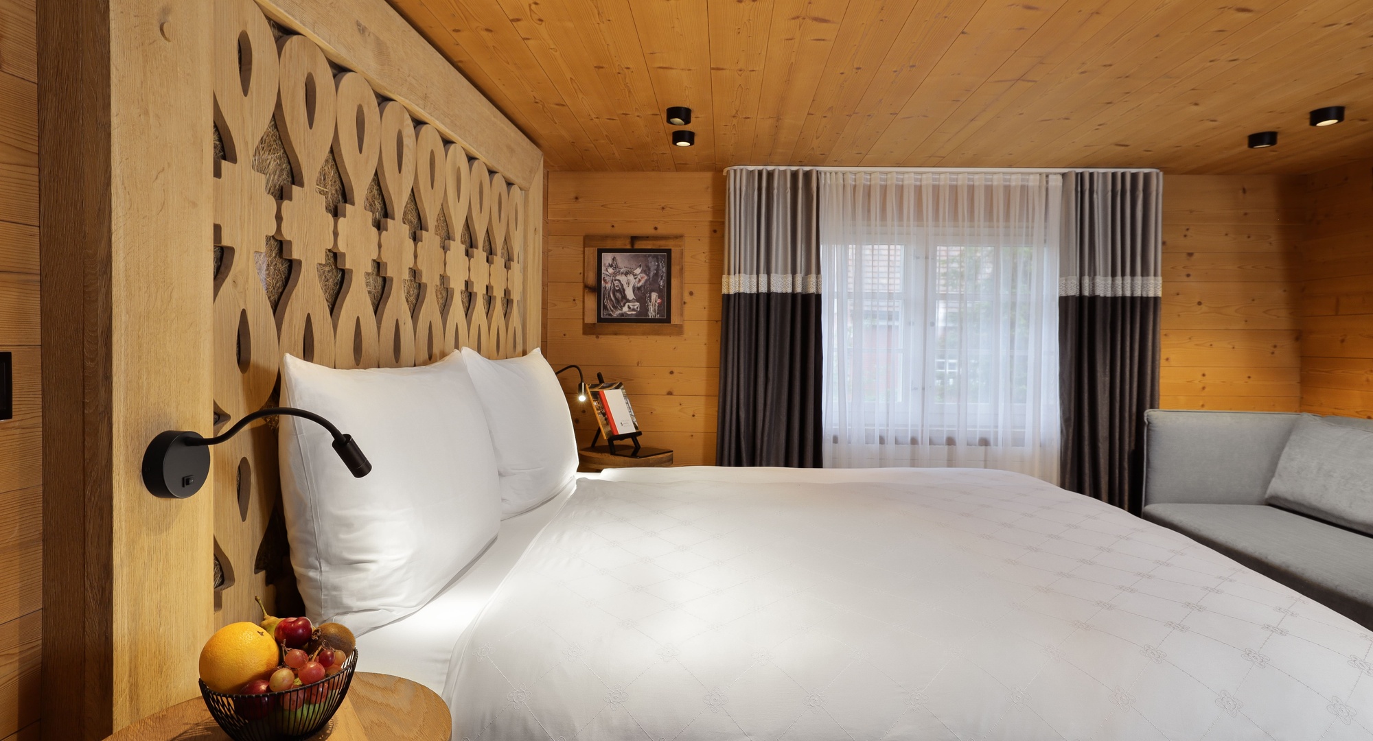 a bed with white sheets and a lamp in a room