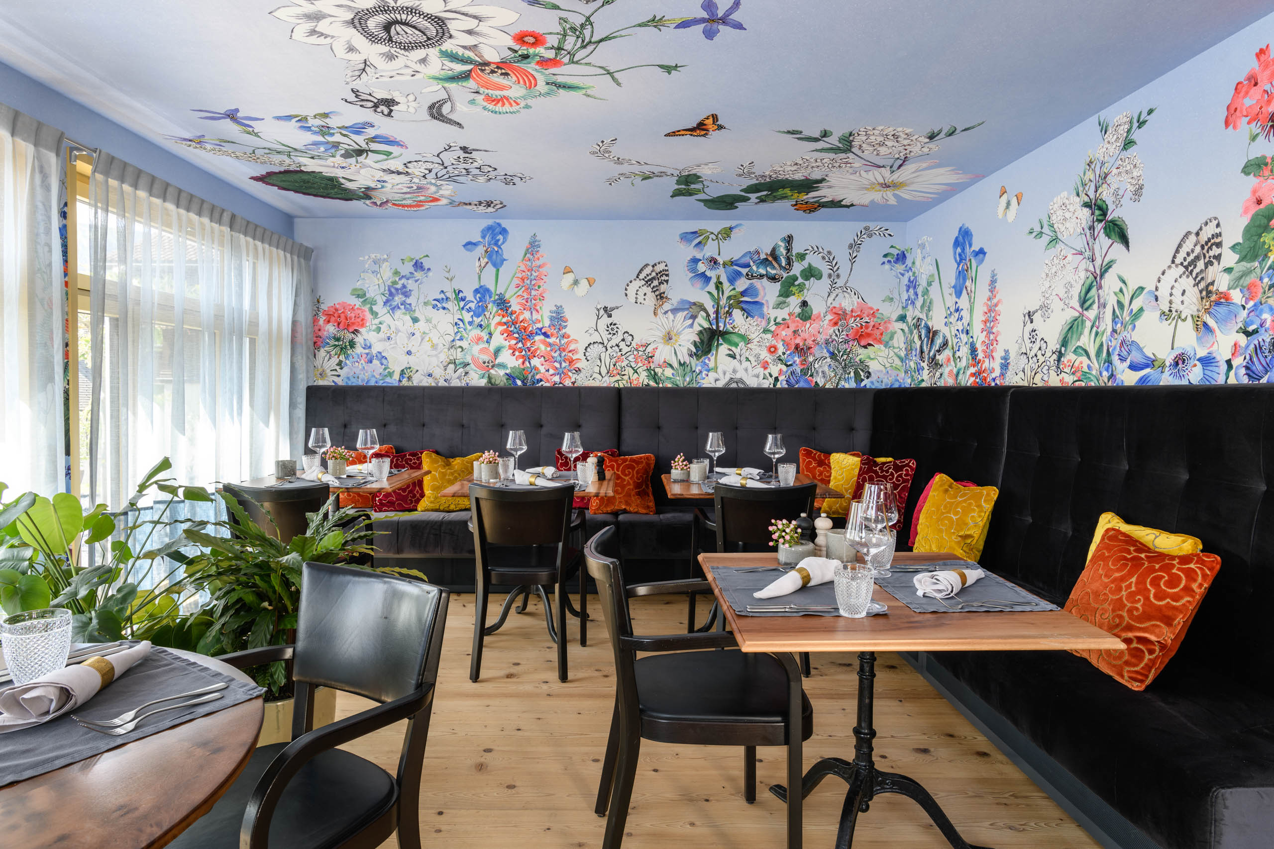 a restaurant with floral wallpaper and flowers