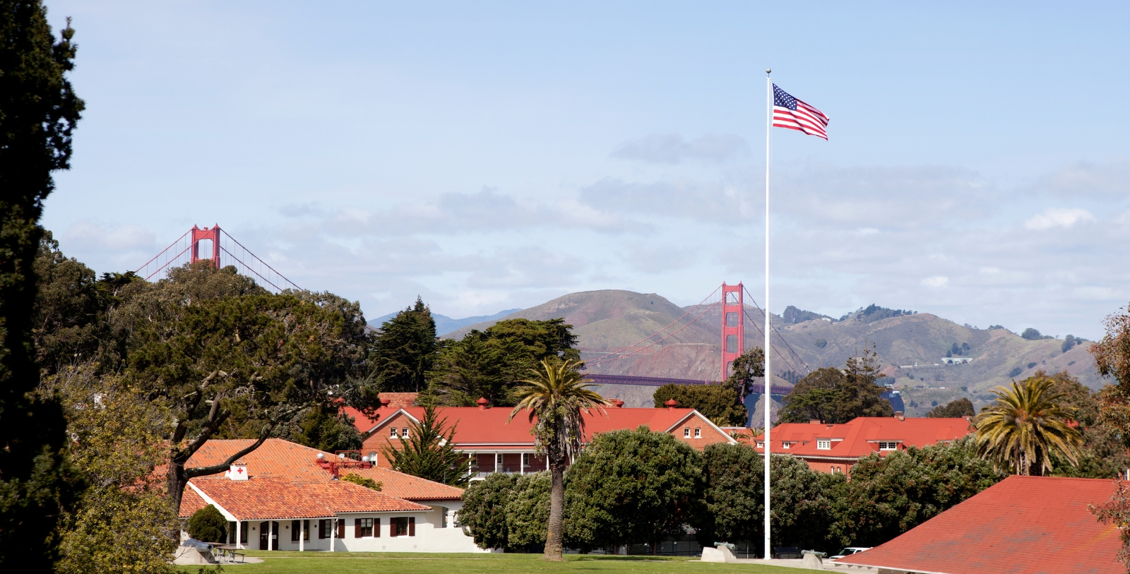 a flag on a flagpole in front of a red bridge