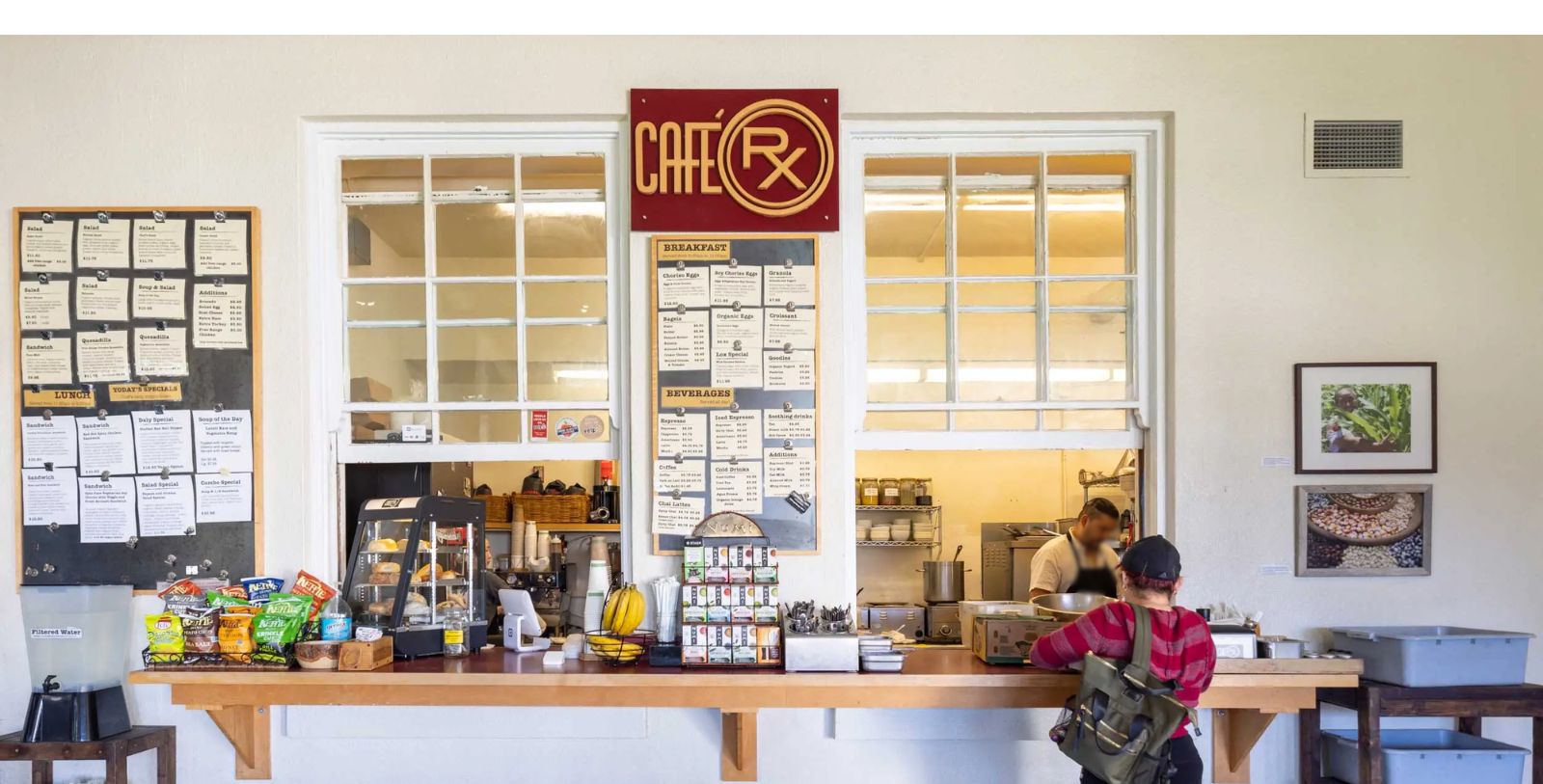 a man standing behind a counter in a cafe
