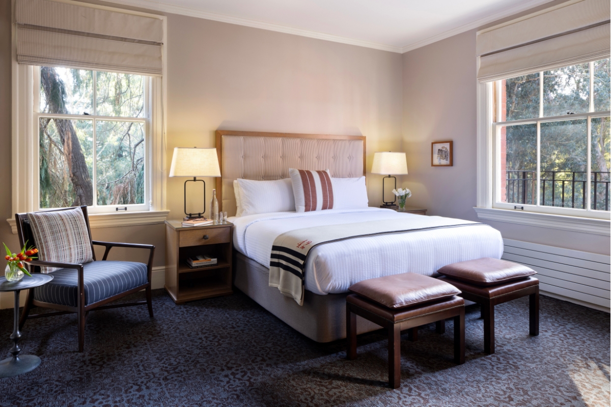 a bed with a chair and a table in a room