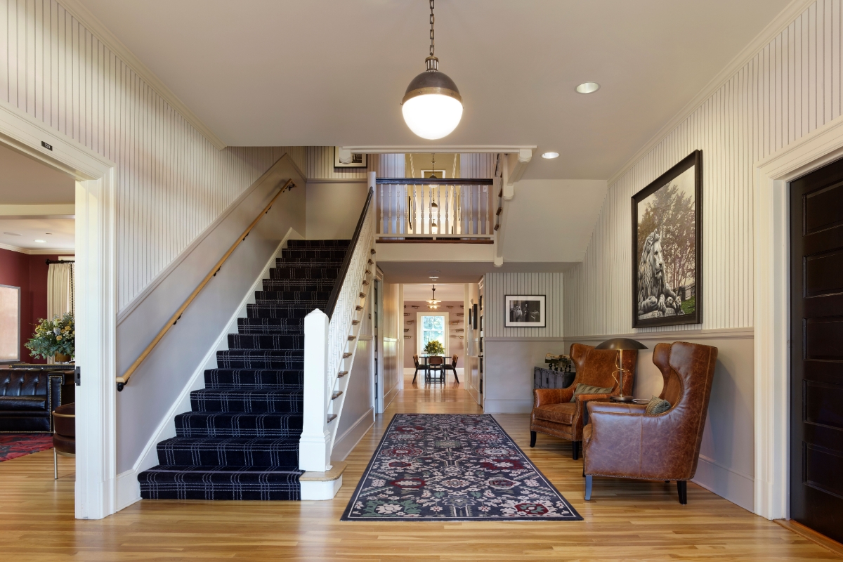 a hallway with a staircase and chairs